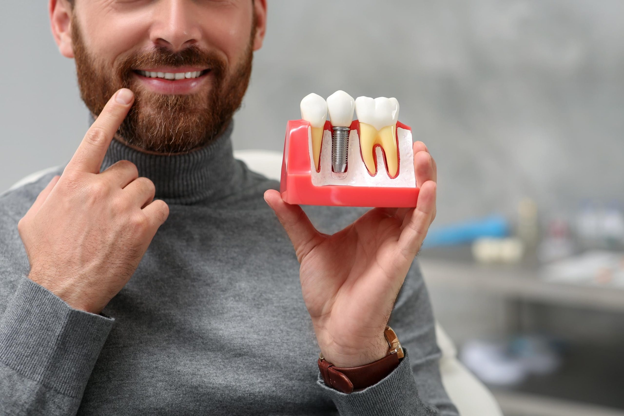 Man,Holding,Educational,Model,Of,Dental,Implant,On,Blurred,Background,